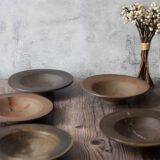 Wood-fired ceramic dishes and a dried flower arrangement on a weathered wooden table — Life with Kogei